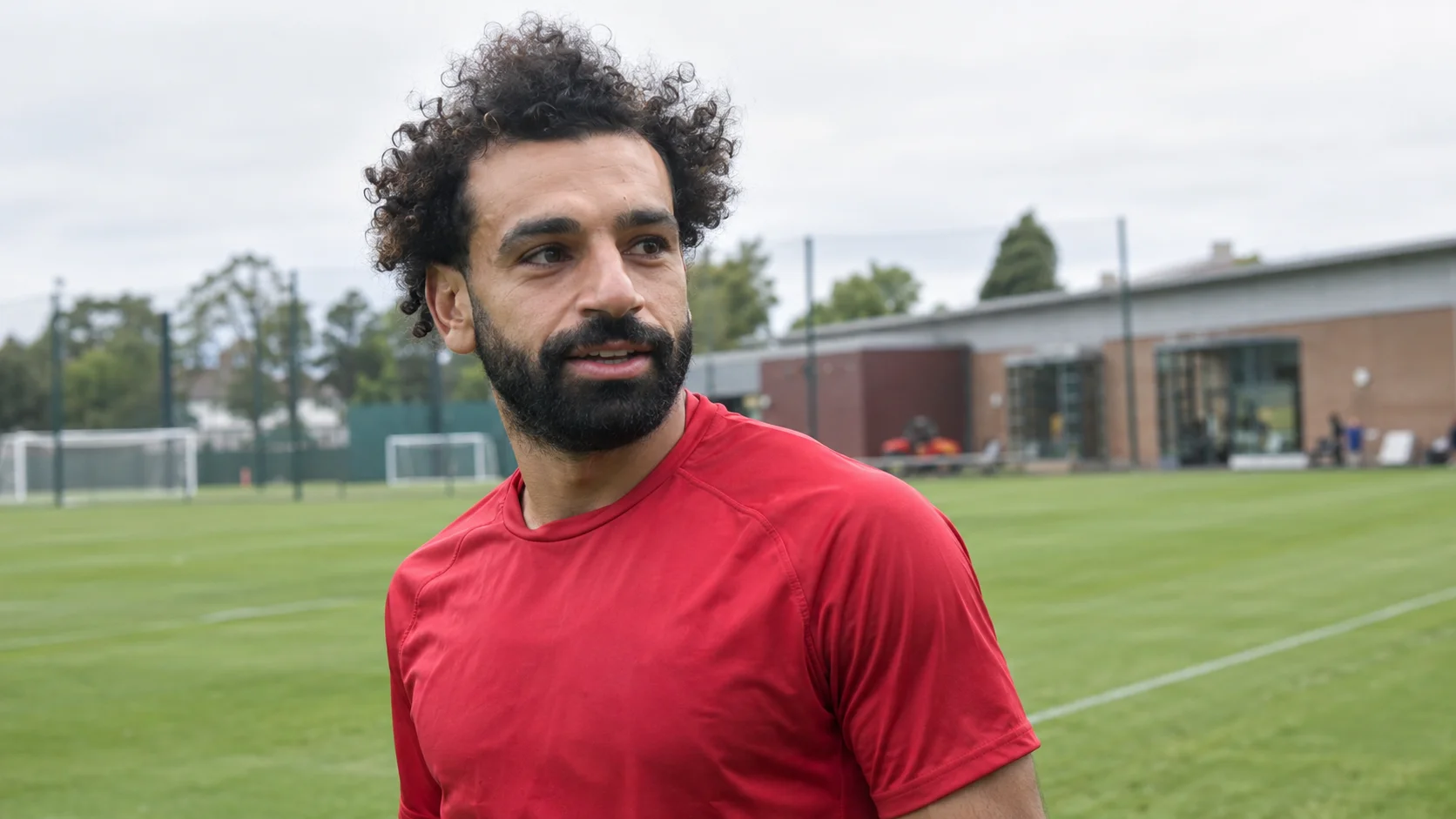 تصور فوتوغرافي لمحمد صلاح بقميص تدريب أحمر في ملعب